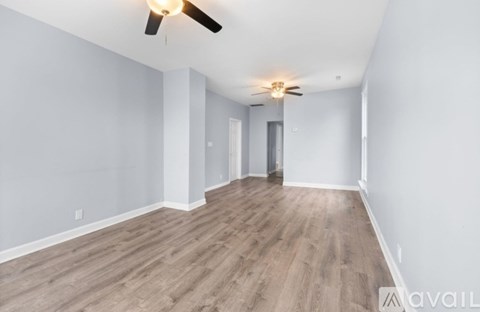 A spacious room with a ceiling fan and lighting fixture.