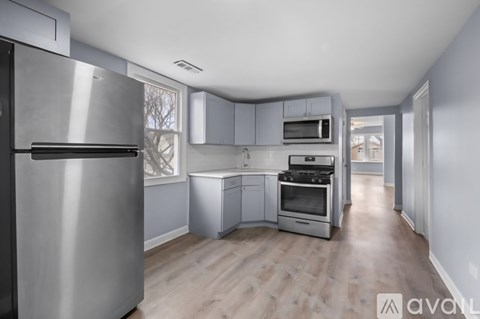 A kitchen with a refrigerator, oven, and microwave.