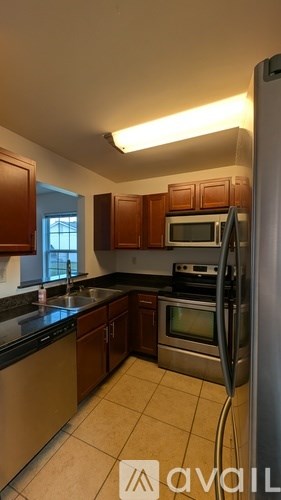 A kitchen with a refrigerator, oven, and sink.