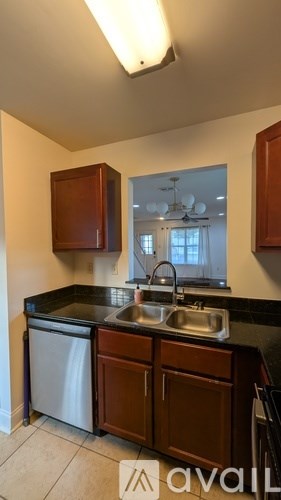A kitchen with brown cabinets and a black countertop.