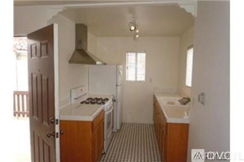 A kitchen with a stove top oven and a refrigerator.