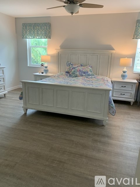 A bedroom with a large bed and a ceiling fan.