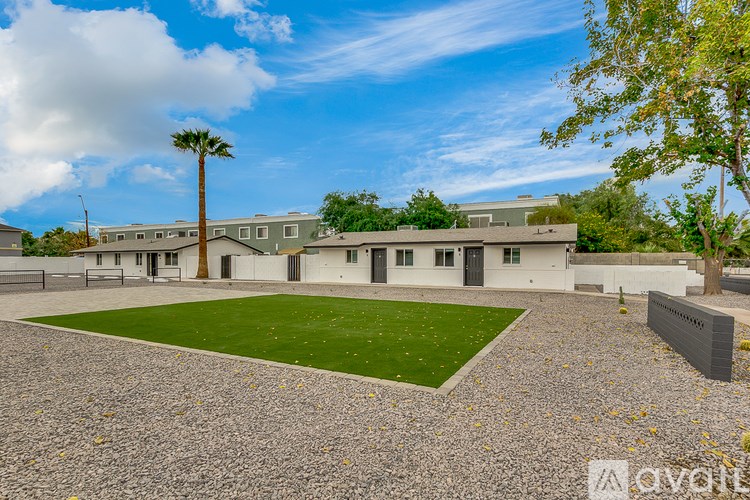 A large building with a green lawn in front and a palm tree to the left.