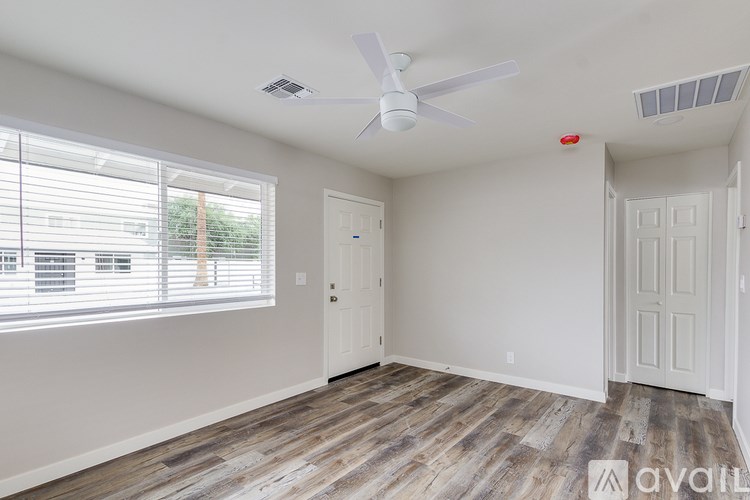 A room with a ceiling fan and two doors.