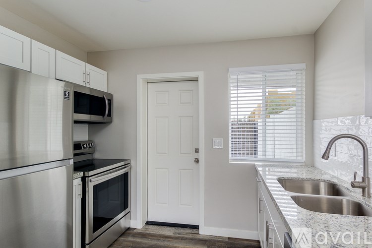 A kitchen with stainless steel appliances and white cabinets.