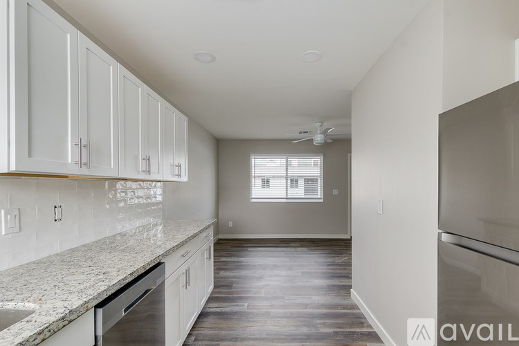 A kitchen with white cabinets and a marble countertop.