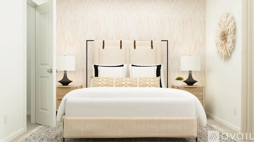 A bed with a white headboard and pillows is in the center of a room with two lamps on either side.