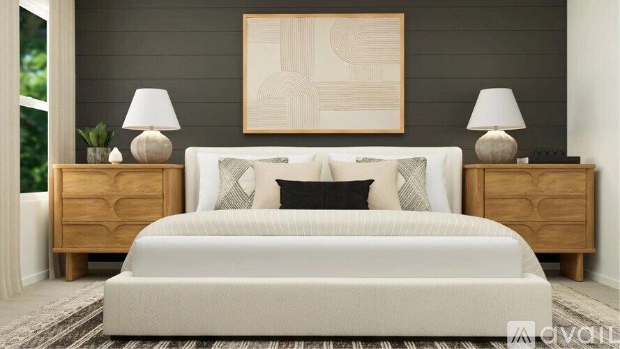 A bedroom with a large bed, two lamps, and a painting on the wall.