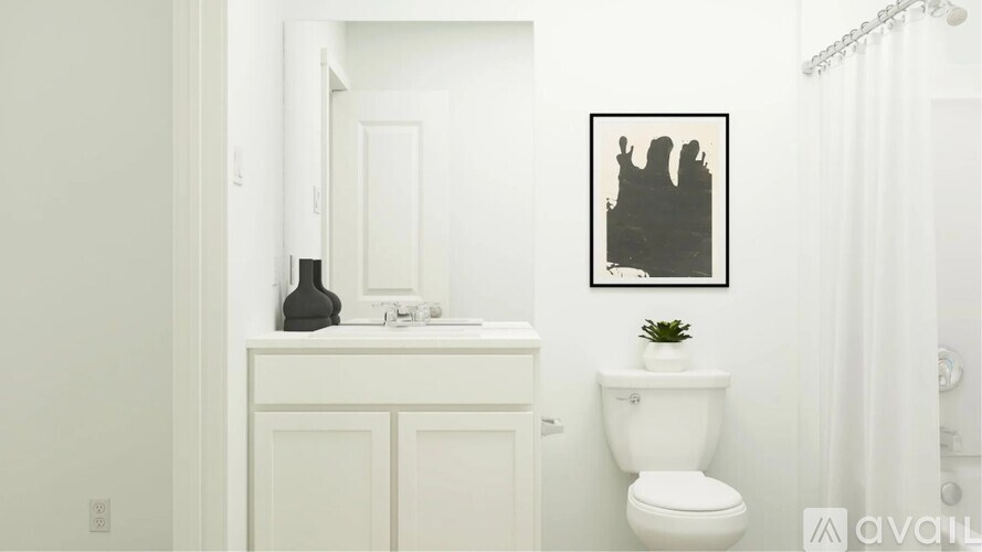 A bathroom with a toilet, sink, and a picture on the wall.