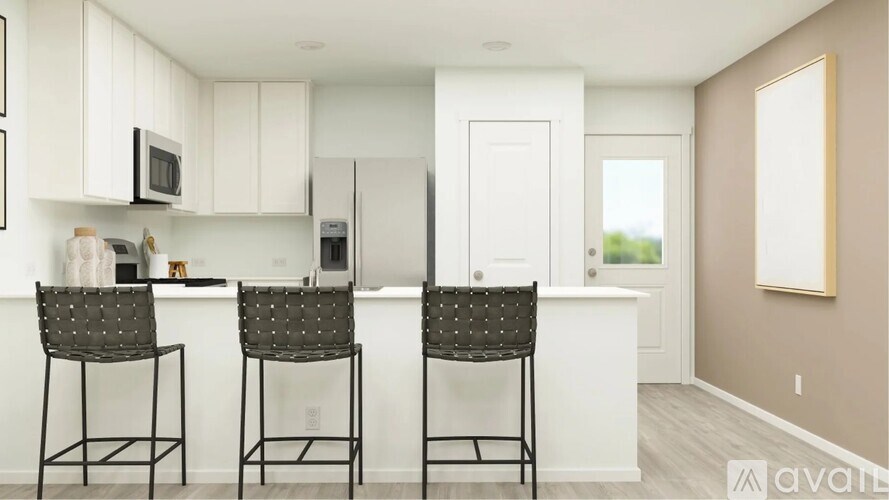 A kitchen with white cabinets and a white island with two chairs.