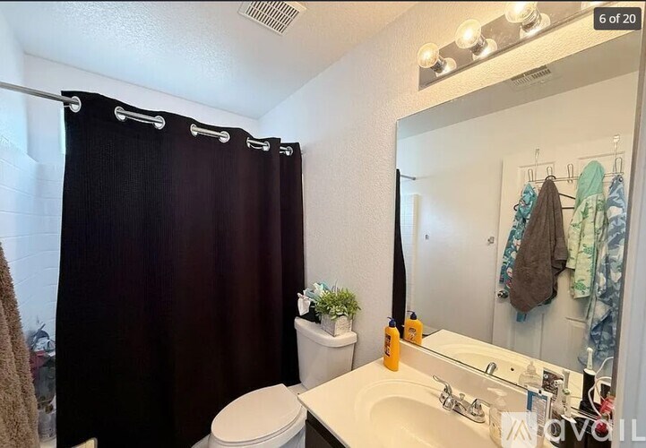 A bathroom with a toilet, sink, and a mirror.