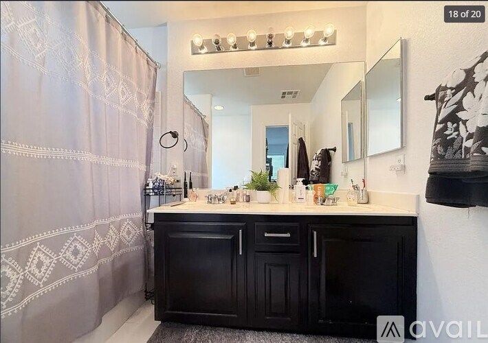 A bathroom with a black vanity and a shower curtain.