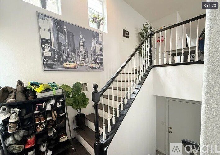 A staircase with a black railing and a poster on the wall.