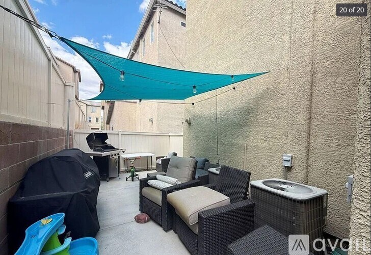 A patio with a hot tub and a canopy.