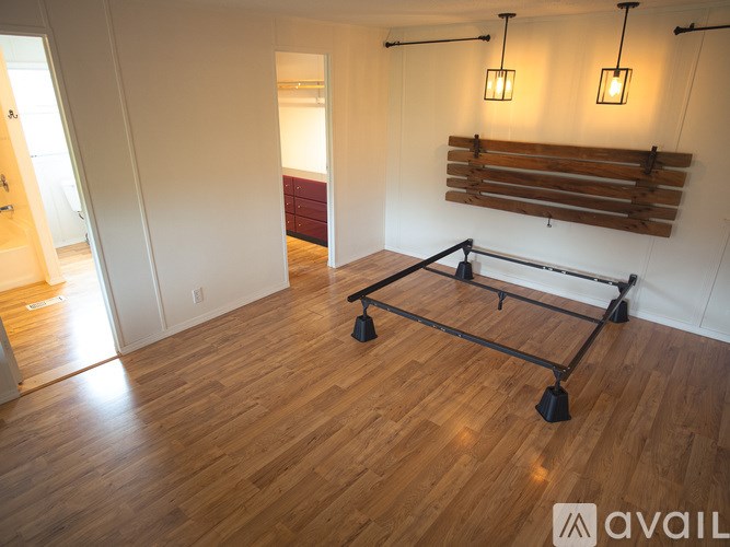 A room with wooden floors and a trampoline in the middle.