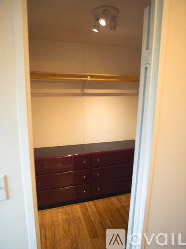 A room with a white wall and a row of drawers.