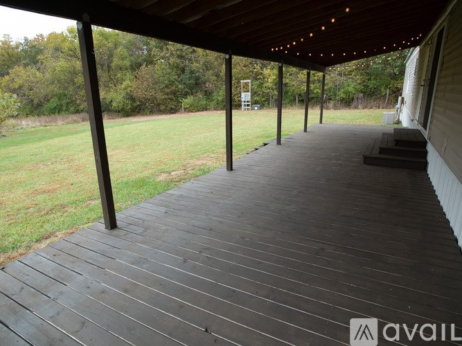 A wooden deck with lights under a roof.