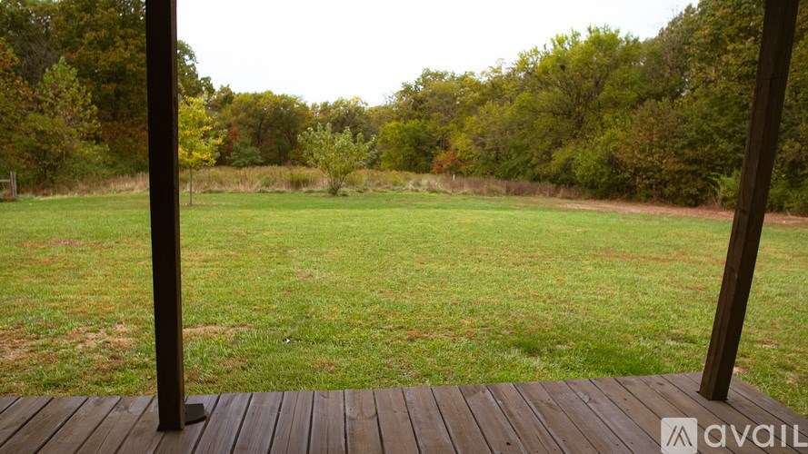 A wooden deck overlooks a grassy field.