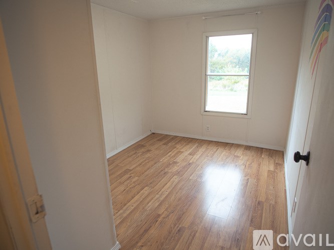 A room with wooden flooring and a window.