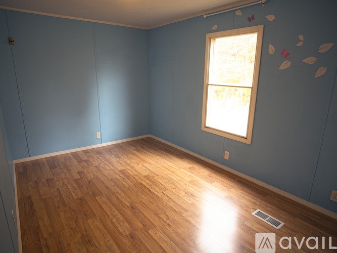 A room with wooden flooring and a window.