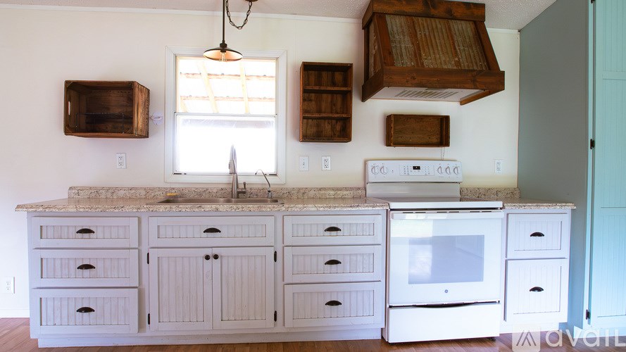 A kitchen with a granite countertop and white cabinets.