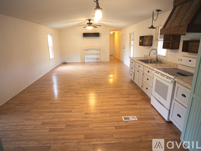 A kitchen with wooden floors and white appliances.