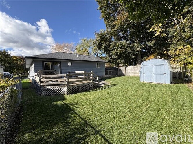 A house with a fenced yard and a shed.