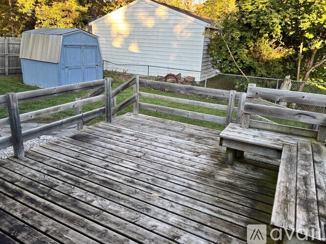A wooden deck with a bench and a fence.