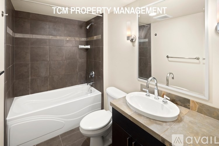 A bathroom with a tub, toilet, and sink.