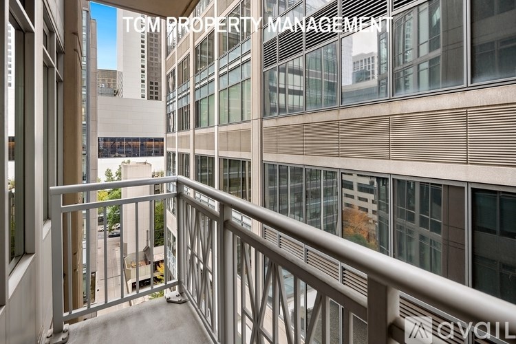 A balcony with a metal railing and glass windows of a building.