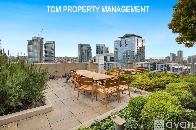 A patio with a table and chairs overlooking a city skyline.