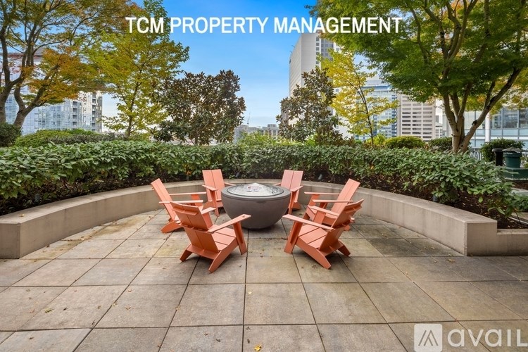 A patio with four chairs and a table is set up on a rooftop.