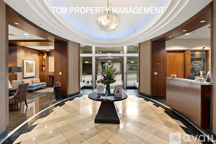 A well-lit, spacious lobby with a reception desk and a large, central table.