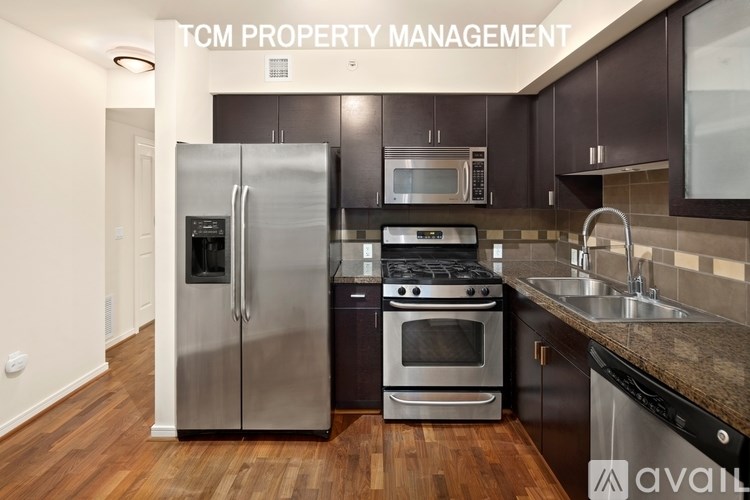 A kitchen with a stainless steel refrigerator, microwave, oven, and sink.