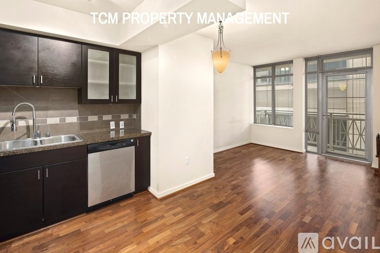 A kitchen with dark wood cabinets and a stainless steel dishwasher.