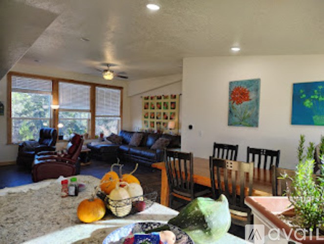A living room with a couch, chairs, and a table with fruit on it.