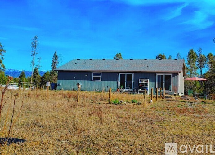 A landscape with a fence, a tree, and mountains in the distance.