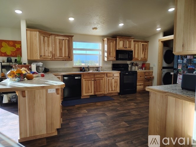 A kitchen with wooden cabinets and black appliances.