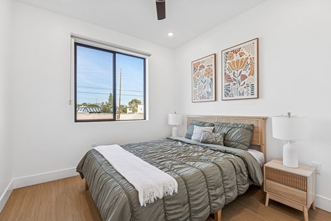 A bedroom with a large bed and two framed pictures on the wall.