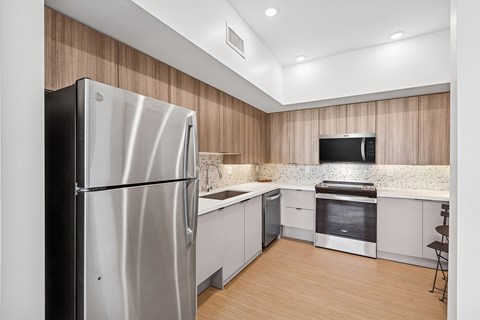 A modern kitchen with a stainless steel refrigerator and a built-in oven.