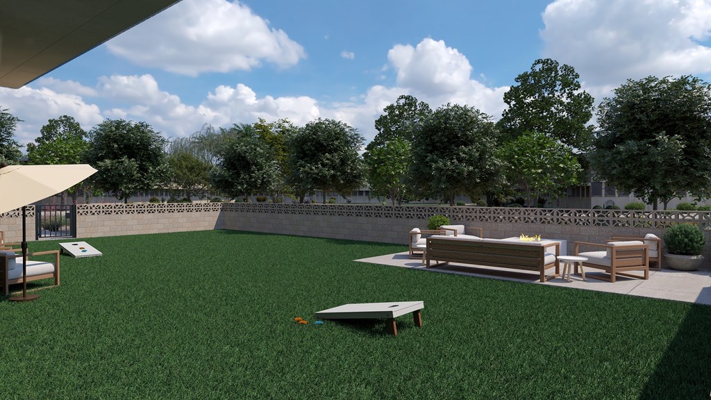 A park with a grassy area, benches, and trees.