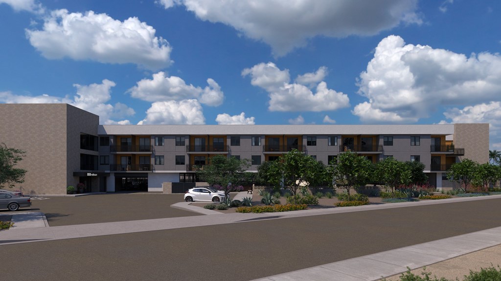 A modern building with a parking lot in front.