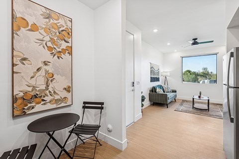 A living room with a painting of oranges on the wall.
