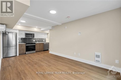 A spacious kitchen with a refrigerator, microwave, oven, and cabinets.