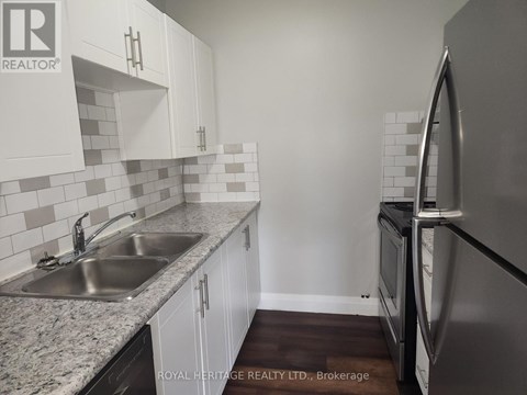 A kitchen with white cabinets and a granite countertop.