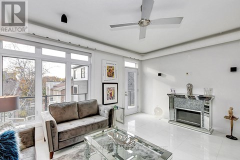 A living room with a grey couch and a glass coffee table.