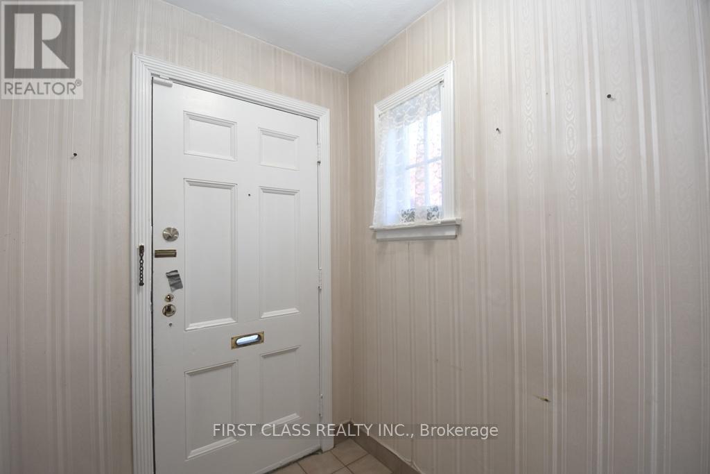 A white door with a window above it in a room.