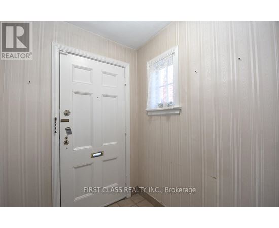 A white door with a window above it in a room.