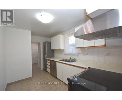 A kitchen with a sink and a stove top oven.