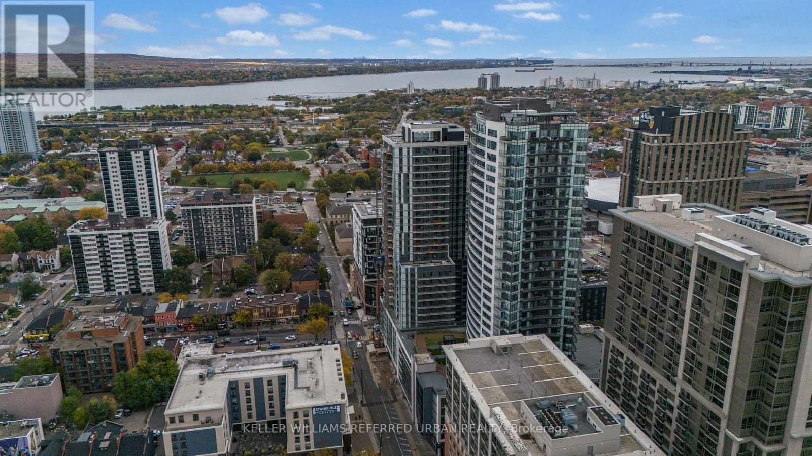 A cityscape with tall buildings and a river in the background.